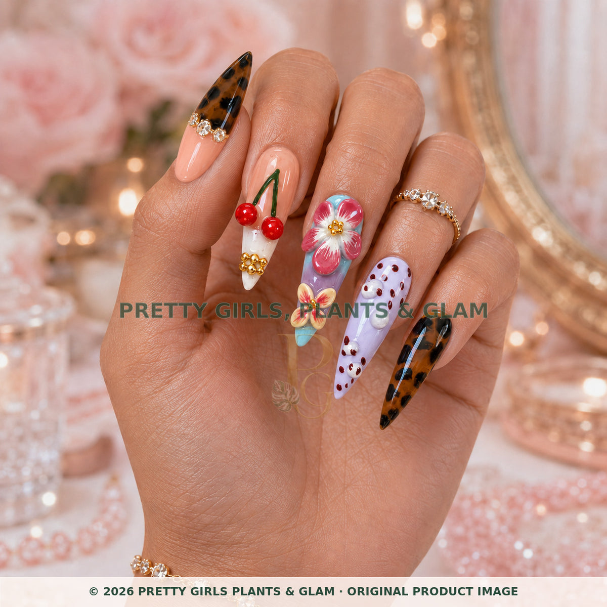 Cherry Muse press-on nails modeled upright on a hand