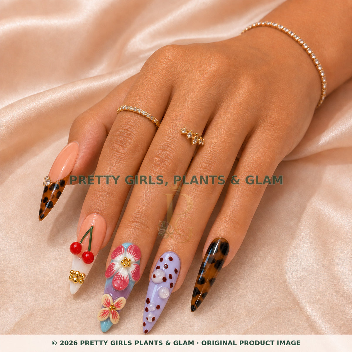 Cherry Muse press-on nails modeled on a hand