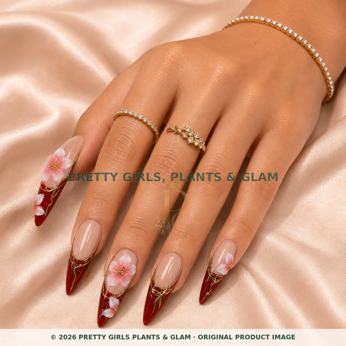 Merlot Bloom press-on nails modeled on a hand