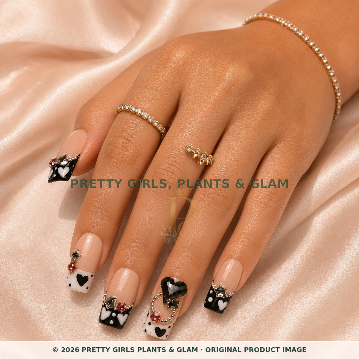 Noir Hearts press-on nails modeled on a hand