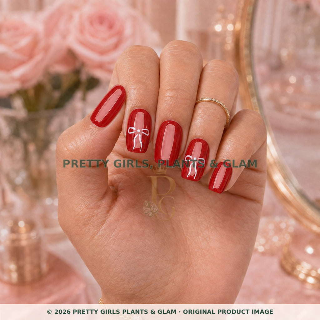 Red Ribbon press-on nails modeled upright on a hand